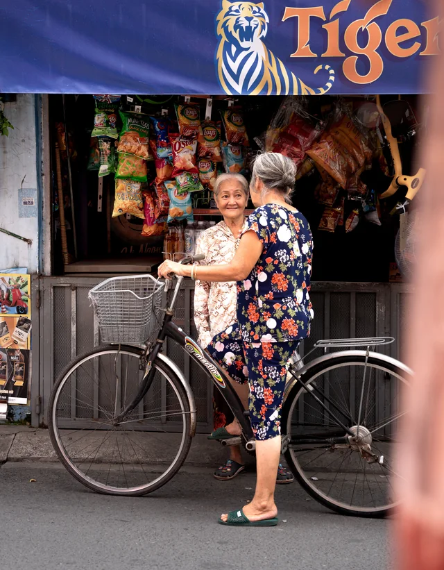 Two older women talking in front of a neighbourhood shop
