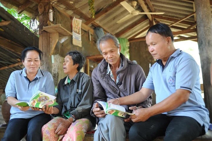 Four people reading and discussing information together