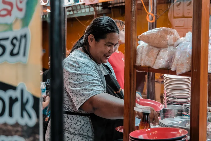 A food-business operator smiling as she works behind the counter